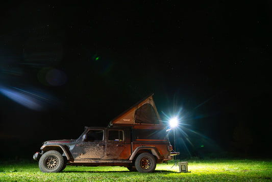 night time overlanding image of an offroad vehicle w/roof tent. Scene is lit up by a FLi OVER-LANDER