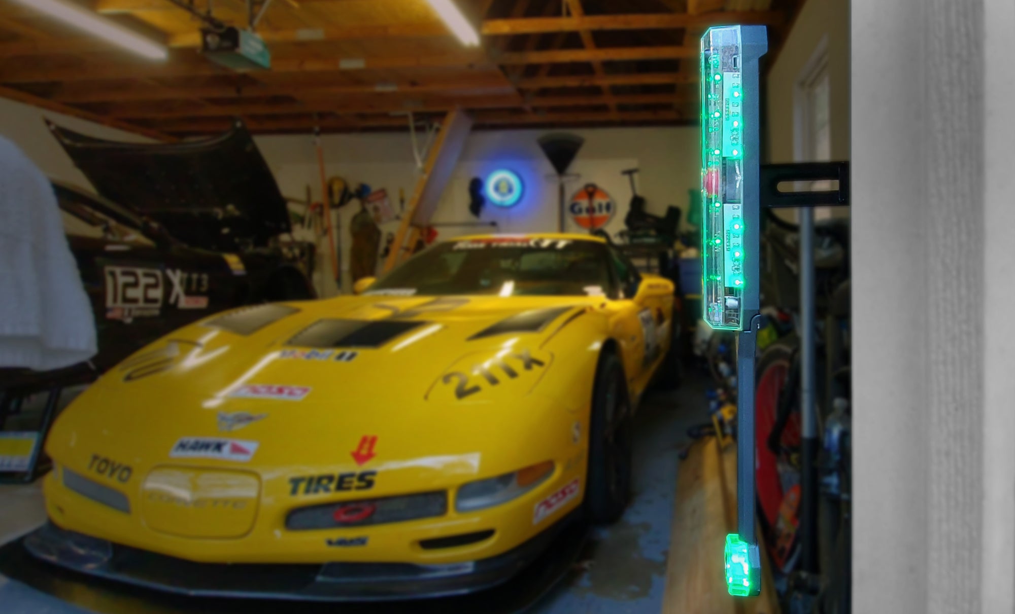 Yellow Corvette backed into a garage. STKR side sensor in the foreground.