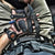 pov pic of a male's lap full of tactical gear including a BAMFF 10.0 tactical flashlight, knife, multitool, key-bar, tactical watch, and a handgun tucked into hit belt
